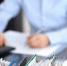 Binders with papers are waiting to be processed with businesswoman or secretary back in blur. - ИА Общественная служба новостей
