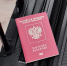 Russian passport on a black travel suitcase, top view, selective background. Emigration of Russians, seeking asylum - ИА Общественная служба новостей