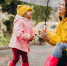Mother with daughter walking in park in the rain wearing rubber boots - ИА Общественная служба новостей