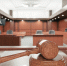 Interior of an empty courtroom with gavel and sounding block on the desk. - ИА Общественная служба новостей