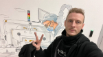 Художник Алексей Бевзенко на фоне своих работ на площадке особой экономической зоны